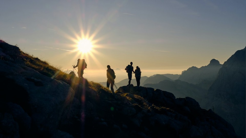 Friends on a mountain ridge at sunrise