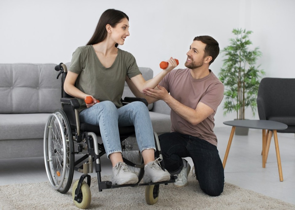 A physical therapist coaching a patient through a dumbbell exercise at home